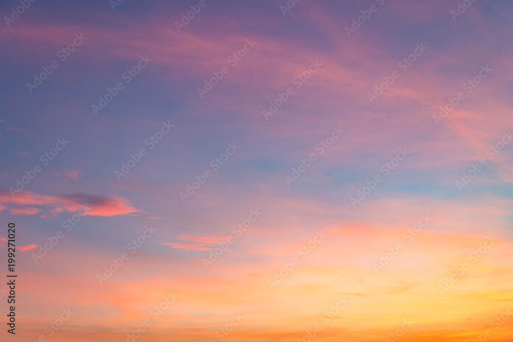 the sky at sunset with purple orange and blue hues. traces of aircraft and light clouds