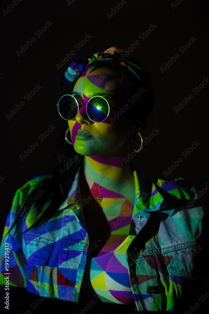 Pretty woman with colorful light on face and sunglasses Pretty woman with colorful light on face and sunglasses