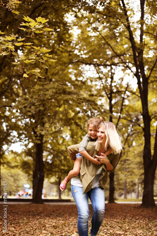 Little girl on a piggy back ride with her mother.