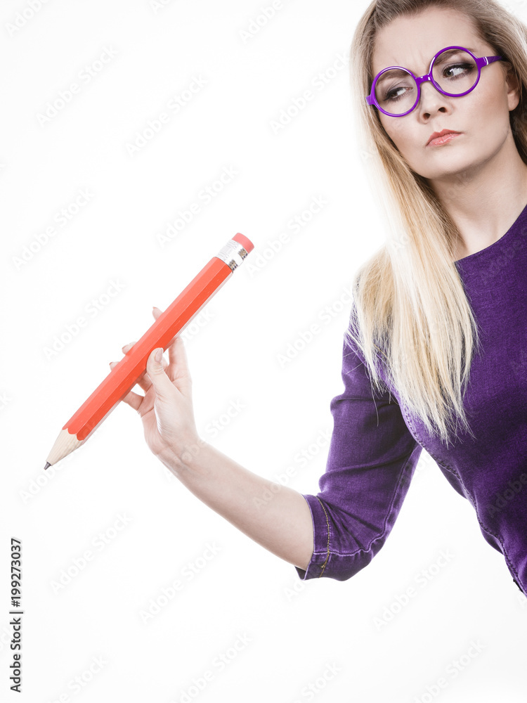 Serious woman holds big pencil in hand