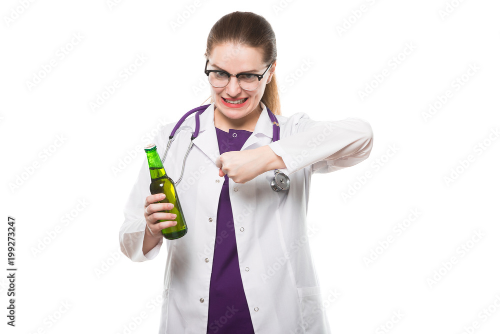 Attractive caucasian brunette female doctor standing in office with bottle of beer in her hands showing prevention sign on white background Attractive caucasian brunette female doctor standing in office with bottle of beer in her hands showing prevention sign on white background