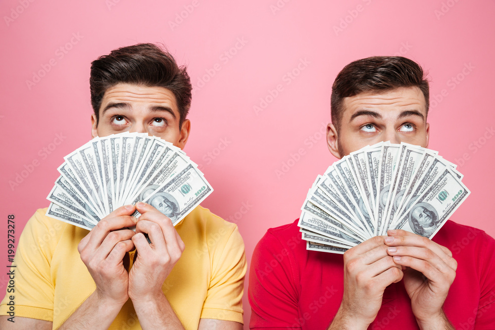 Portrait of a happy gay male couple holding money Portrait of a happy gay male couple holding money