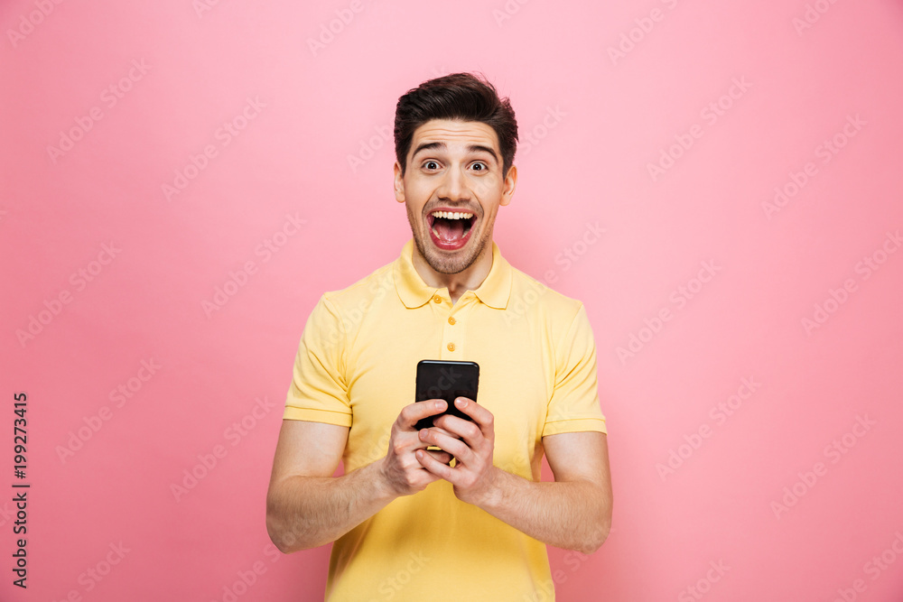 Portrait of an excited young man holding mobile phone Portrait of an excited young man holding mobile phone