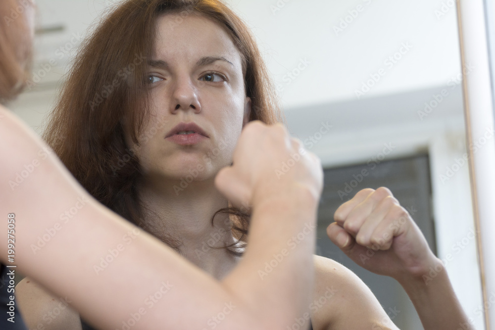 A display of anger and sadness in the mirror from a redhead model A display of anger and sadness in the mirror from a redhead model