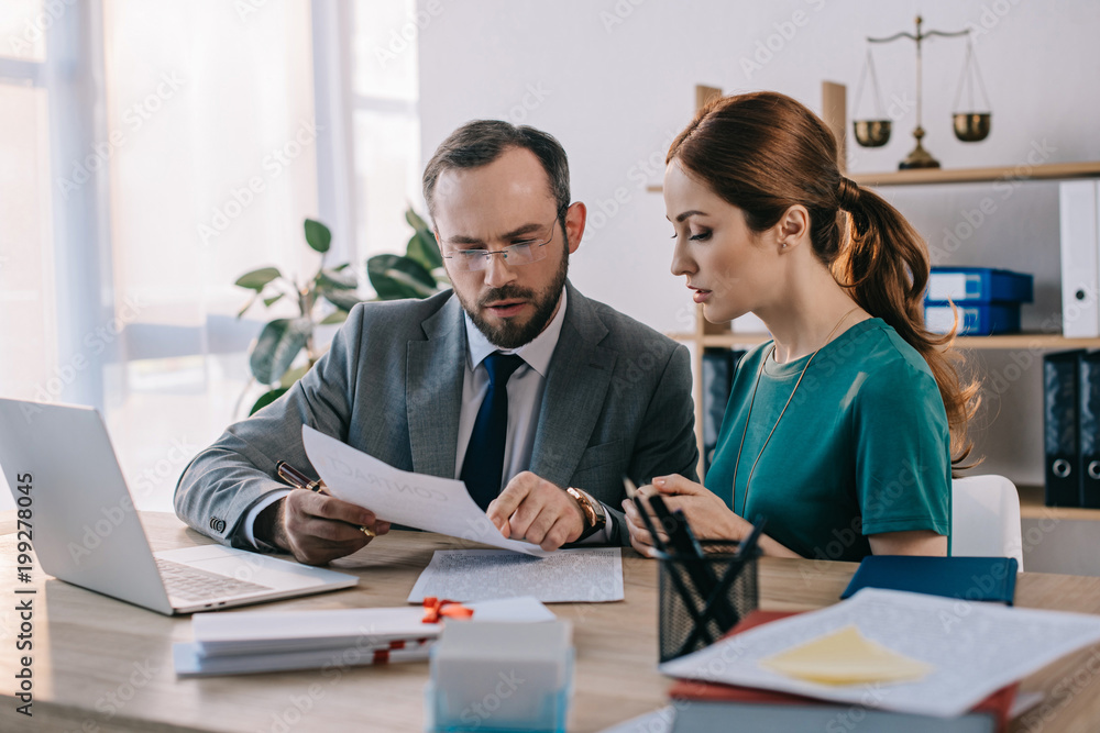 lawyer and client discussing contract at workplace with laptop in office lawyer and client discussing contract at workplace with laptop in office
