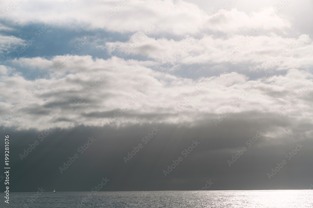 White boat in the ocean. Dramatic clouds in the sky