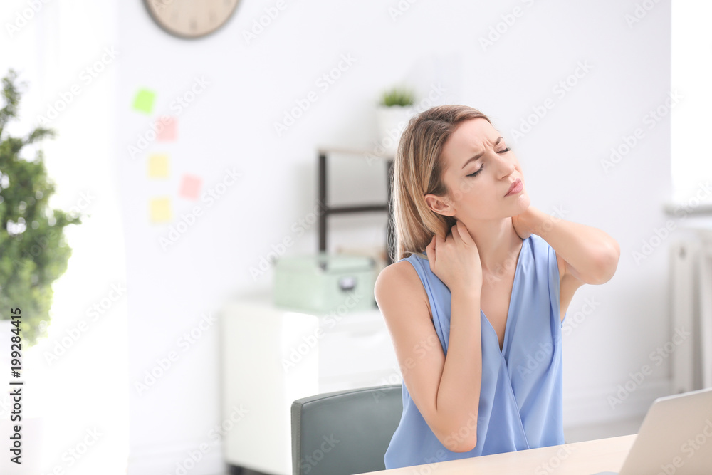 Young woman suffering from neck pain in office Young woman suffering from neck pain in office