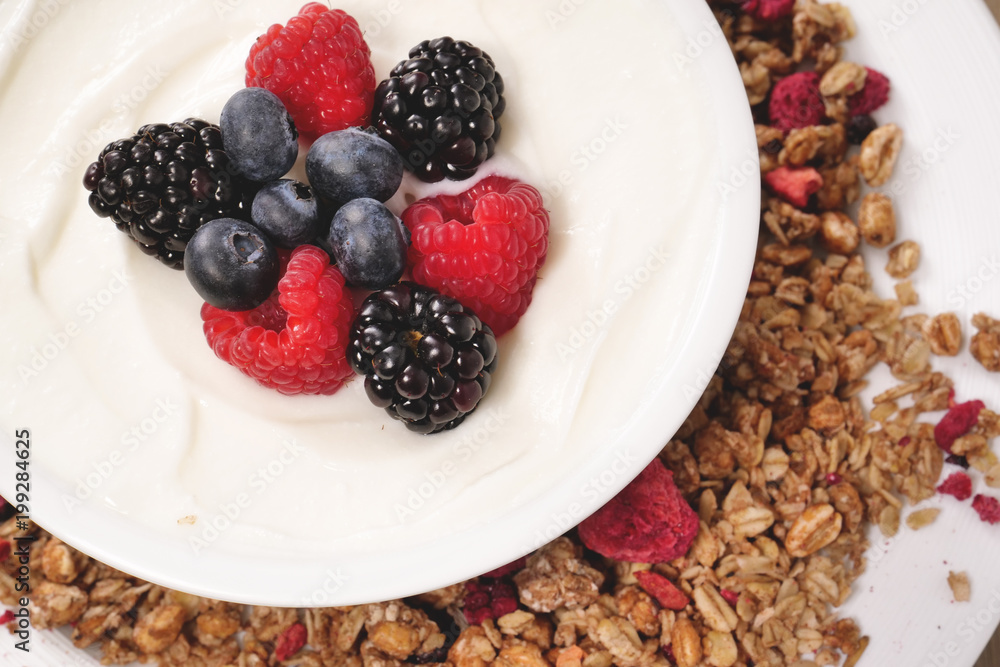 Composition of a typical genuine breakfast made with strawberry yogurt and granola. Concept of: fitness, diet, wellness and strawberries. Composition of a typical genuine breakfast made with strawberry yogurt and granola. Concept of: fitness, diet, wellness and strawberries.