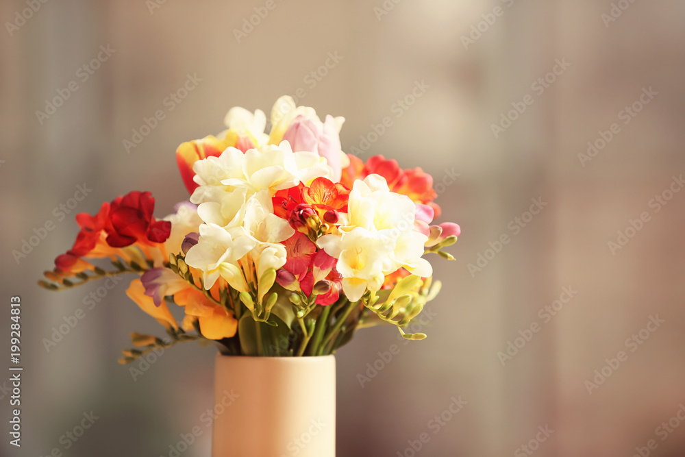 Beautiful bouquet of freesia flowers on blurred background