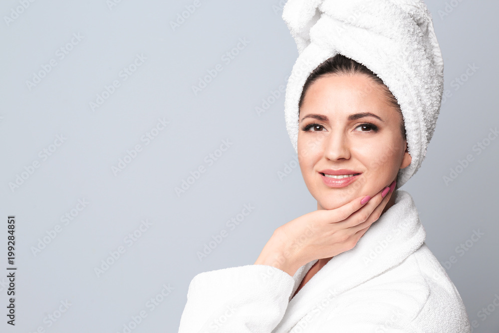Beautiful woman with clean skin touching her face on light background Beautiful woman with clean skin touching her face on light background