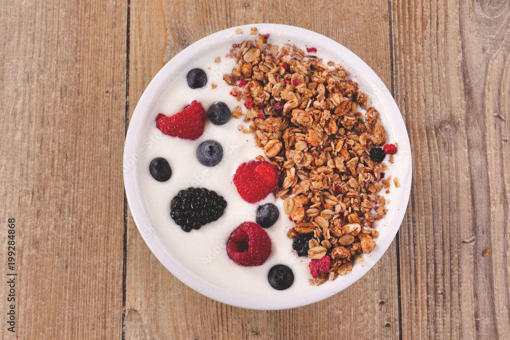 Composition of a typical genuine breakfast made with strawberry yogurt and granola. Concept of: fitness, diet, wellness and strawberries. Composition of a typical genuine breakfast made with strawberry yogurt and granola. Concept of: fitness, diet, wellness and strawberries.