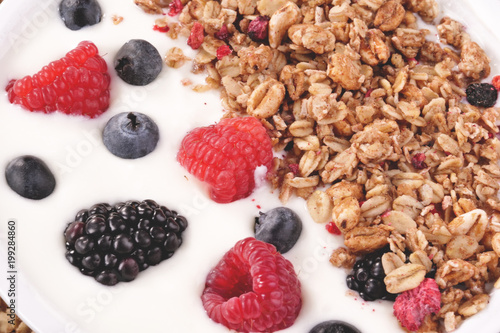 Composition of a typical genuine breakfast made with strawberry yogurt and granola. Concept of  fitness  diet  wellness and strawberries.