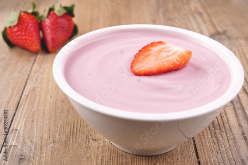 Composition of a typical genuine breakfast made with strawberry yogurt. Concept of: fitness, diet, wellness and strawberries.