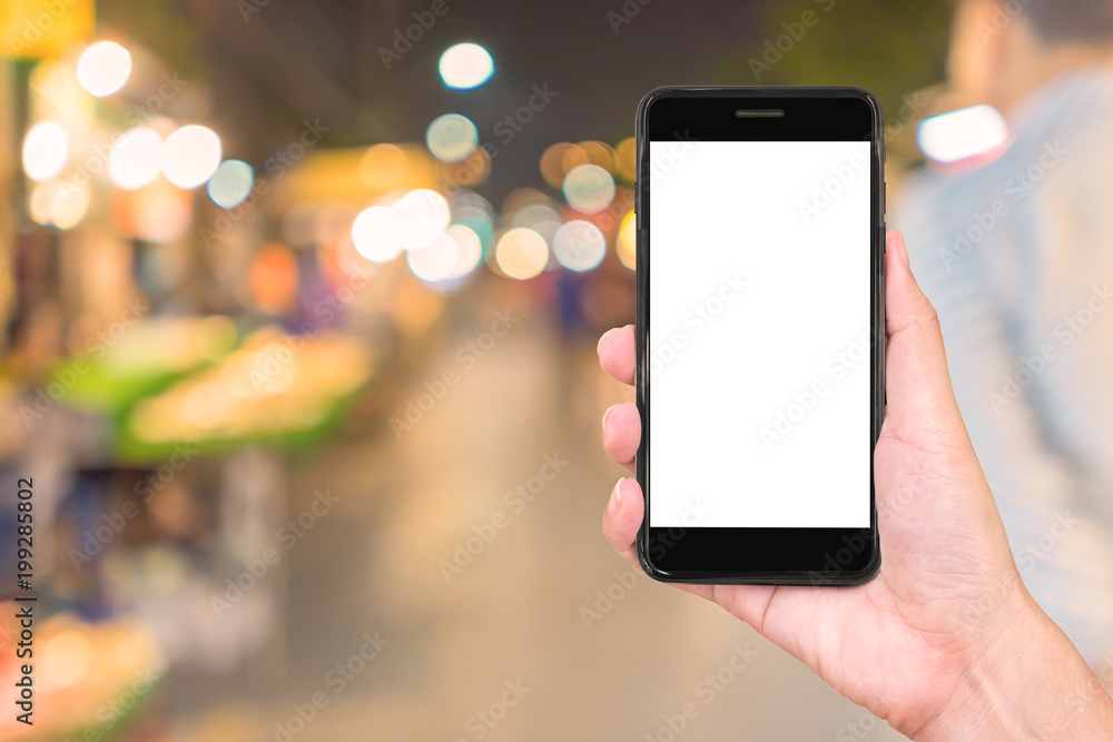 Close up hand holding smartphone in night city background. Close up hand holding smartphone in night city background.