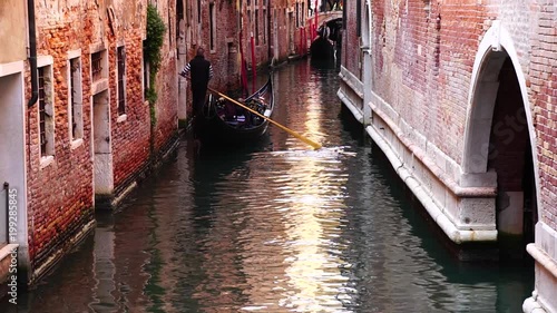 Gondolas pass in a small canal in Venice, Italy
