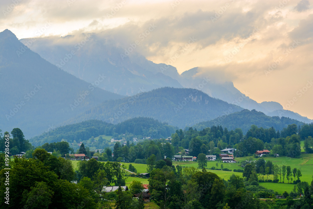 Rural summer landscape with country houses in Alps in early morning