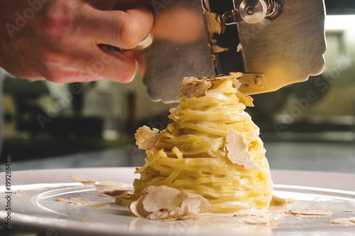 Egg pasta dish, typical Italian, with fine white truffle grated on top. Concept of: gourmet cuisine, truffles, Italian pasta, fine dishes. photo