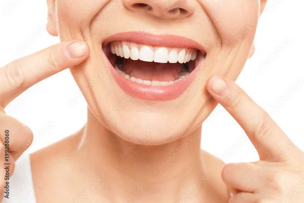 Young woman with beautiful smile on white background, closeup. Teeth whitening