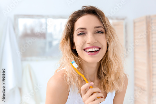 Fototapeta Naklejka Na Ścianę i Meble -  Young woman brushing her teeth in bathroom