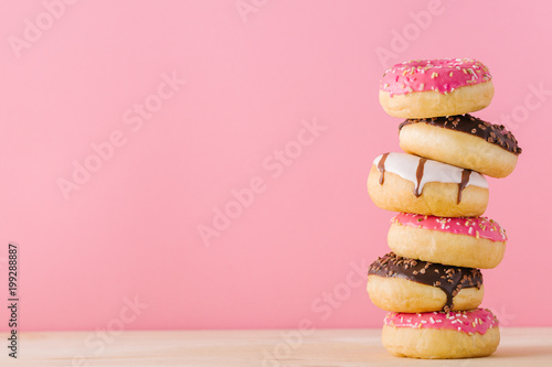 Stack of different donuts on pink