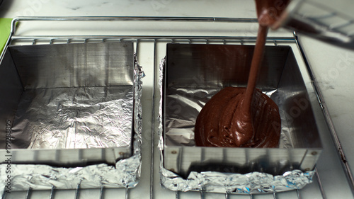 Step-by-step preparation of black designer cake. Filling the dough for baking.