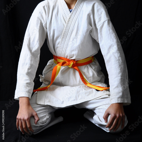 child's hands making a bow on karate belt photo
