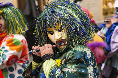 Basel carnival. Schnabelgasse, Basel, Switzerland - February 21st, 2018. Close-up of a flute playing reveler with a beautiful costume and mask