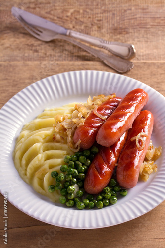 Sausages, mashed potatoes, green peas and onion gravy. Homemade Bangers and Mash