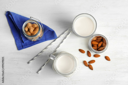 Almond and peanut milk with nuts on wooden background