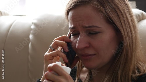 young woman feels sad and crying while speaking with someone on smartphone. 4K
