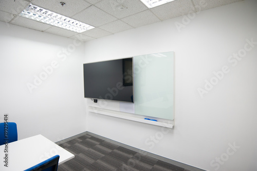 LED TV installed to the white wall of the meeting room with white board