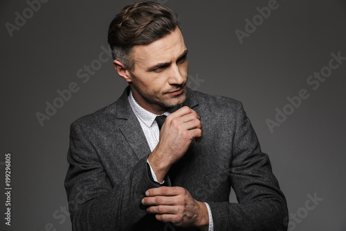 Foto Fashion image of masculine man dressed in business suit looking aside, while fas