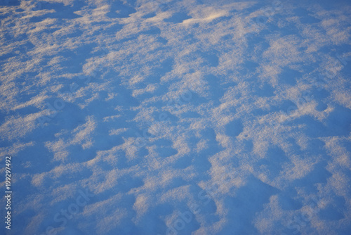 Snow field on sunset with blue shadows. Background texture. High angle view. Copy space.