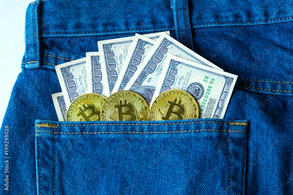 Golden bitcoins and large stack of money in the pocket of old vintage indigo stonewashed jeans. Concept of cryptocurrency and competition with physical money. Modern trendy color Golden bitcoins and large stack of money in the pocket of old vintage indigo stonewashed jeans. Concept of cryptocurrency and competition with physical money. Modern trendy color