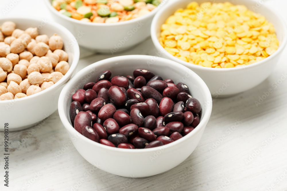 Different beans in bowls on a white wooden table Different beans in bowls on a white wooden table