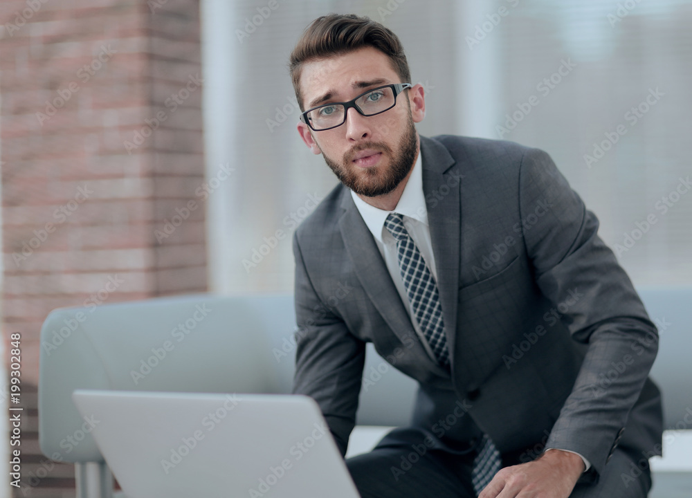 Portrait of a modern businessman sitting at his desk. Portrait of a modern businessman sitting at his desk.