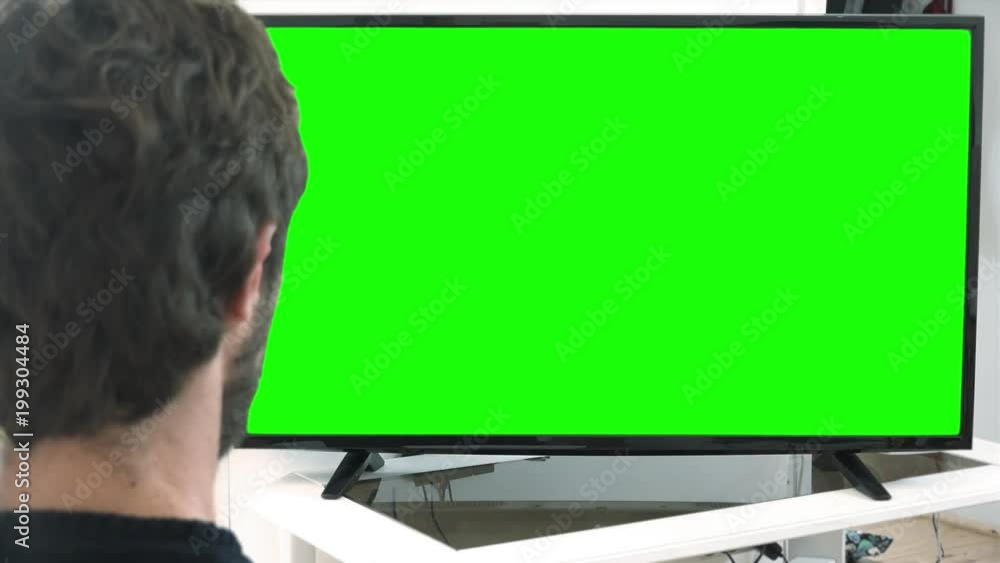 Close Up Watching TV Green Screen. Young man watching big green screen