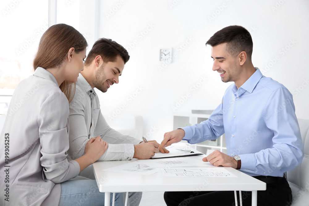 Real estate agent with clients in office Real estate agent with clients in office