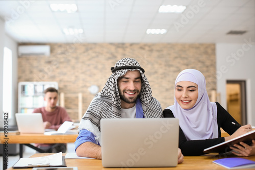 Canvas Print Muslim students in traditional clothes studying indoors