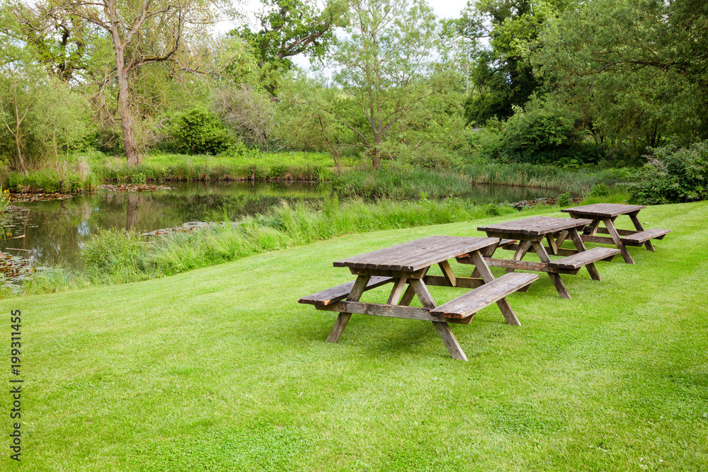 Picnic tables by a pond in Southern England UK Picnic tables by a pond in Southern England UK