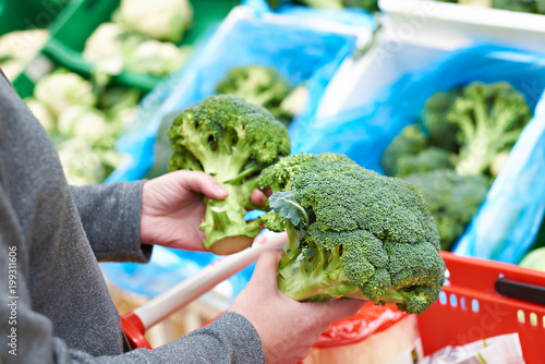 Woman buys broccoli in store