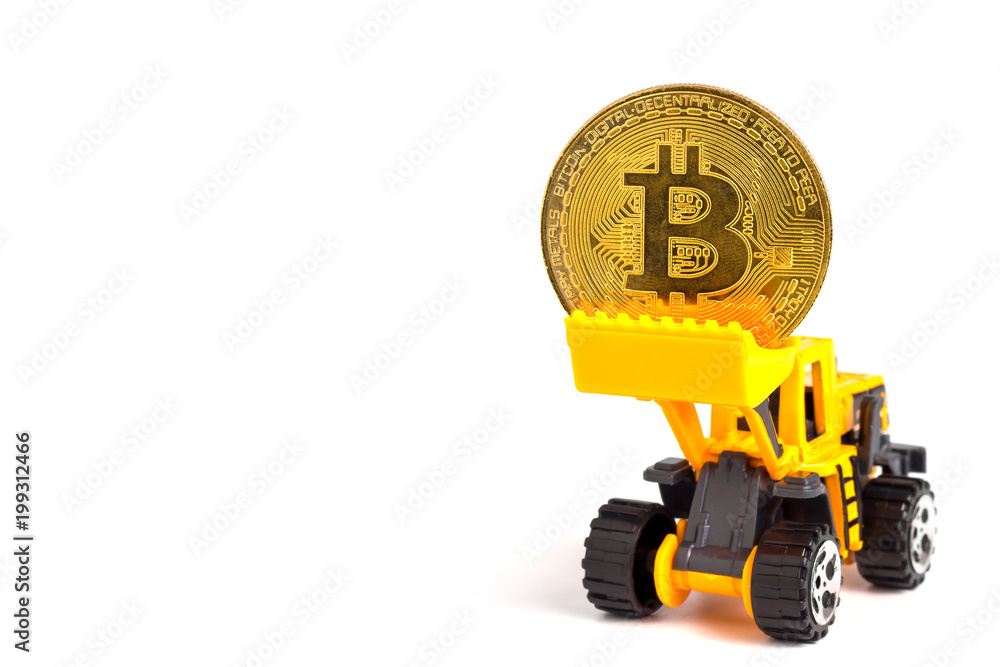 Close up yellow tractor model lifts up the golden coins. The concept of bitcoin mining business.