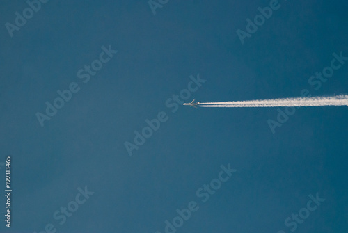 Long trace of the aircraft in the blue sky,