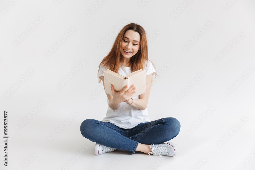 Portrait of a smiling young girl reading book