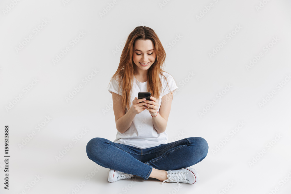 Portrait of a happy young girl using mobile phone