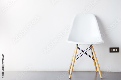 single modern white chair furniture with wood legs with wall in room background photo