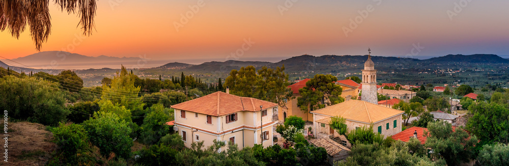 Panoramic view of beautiful sunset on the island of zakynthos with old bell tower of an orthodox church