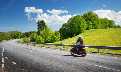 Motobike on asphalt road in beautiful summer evening at countryside