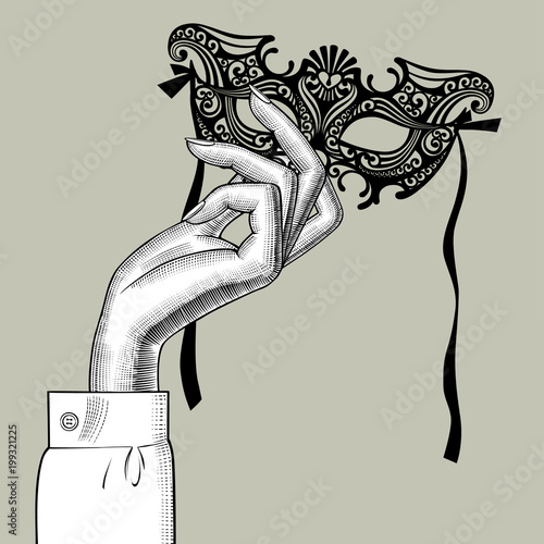 Woman's hand with a decorative carnival Venetian mask