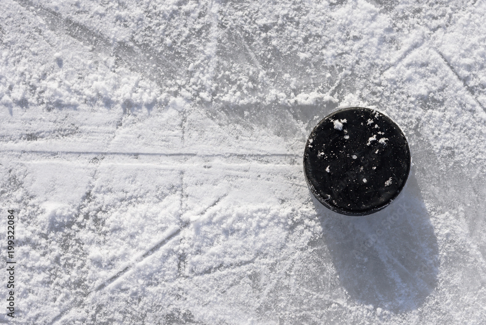 Fototapeta premium hockey puck lies on the ice in the stadium